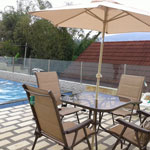 Area kolam renang yang dilengkapi kursi dan meja untuk bersantai